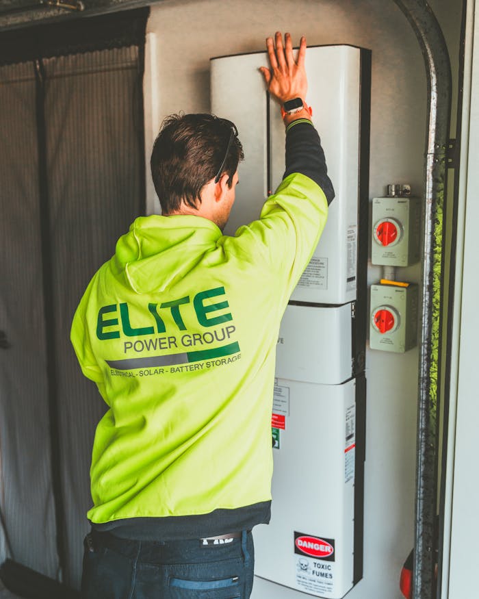 Services Technician installing a solar inverter and battery system in New South Wales.